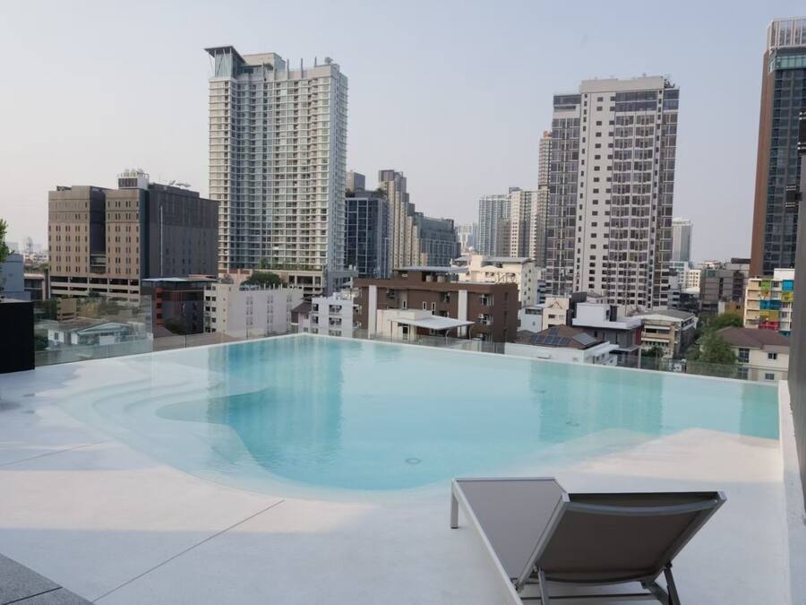 A rooftop pool with a cityscape view, surrounded by modern buildings.