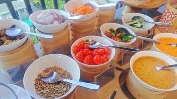 A buffet table with various food items and utensils.