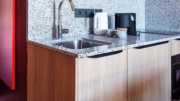Una cocina moderna con encimera de granito, pileta de acero inoxidable y muebles de madera.