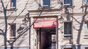 Fachada de edificio con un letrero rojo que dice "Numa Berlin Friedrichshain".