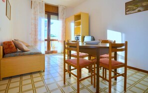 Relax in a spacious room with a dining area, sofa, and large window.