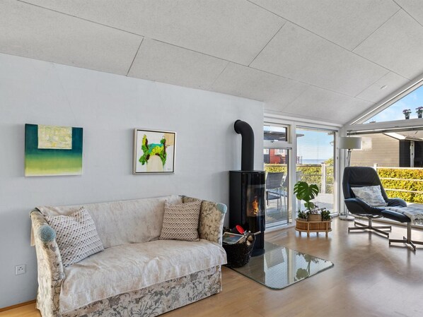 Una sala de estar moderna con un sofá, chimenea y obras de arte en la pared.