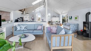 Un salon moderne avec un canapé, une table basse et une cheminée.