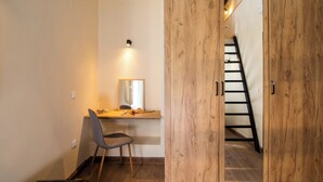 Une pièce comprenant une armoire en bois, un bureau avec une chaise et un miroir.