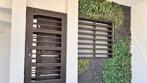 A modern entrance with a metal gate and a vertical garden wall.