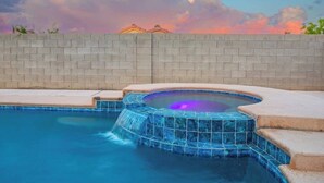 A swimming pool with a hot tub and a brick wall in the background. - Rare 6BR Gem w/ Pickleball, Pool, & Arcade in NLV (North Las Vegas)