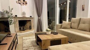 Una sala de estar moderna con chimenea, un sofá, una mesa de centro y un televisor.