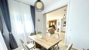 Un comedor con una mesa de madera, cuatro sillas y una planta en maceta.