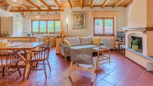 Un intérieur chaleureux comprenant un coin repas, un canapé, une cheminée et une cuisine.