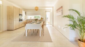 A modern kitchen with wooden cabinets, a dining area with a table set for four, and a large potted plant. - Beautiful private villa for 6 people with WIFI, private pool, A/C and TV, close to Brindisi (San Vito Dei Normanni)