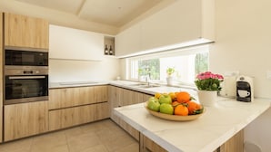 A modern kitchen with built-in appliances, a large window, and a fruit bowl on the counter. - Beautiful private villa for 6 people with WIFI, private pool, A/C and TV, close to Brindisi (San Vito Dei Normanni)