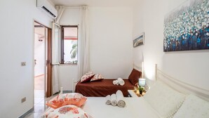 Ein Schlafzimmer mit Bett, Kissen, einem Gemälde und einem Fenster.