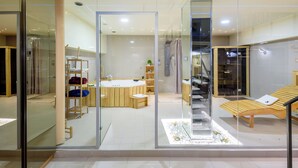 A modern bathroom with a glass partition, a bathtub, a shower area, and a sun lounger. - Xspa Apartment Cryptocurrency pay Available (Novi Sad)