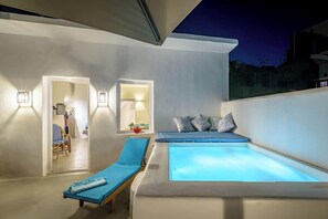 Un'area relax esterna moderna con vasca idromassaggio, poltrone prendisole e un piccolo angolo salotto con cuscini.