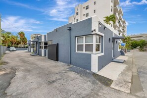 Un bâtiment moderne doté d’un toit plat, de grandes fenêtres et d’une entrée sécurisée par un portail.