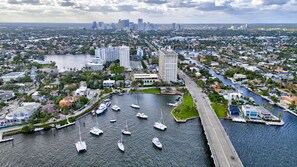 Luchtbeeld van een jachthaven met diverse boten aanmeren, omgeven door woongebouwen en een brug.