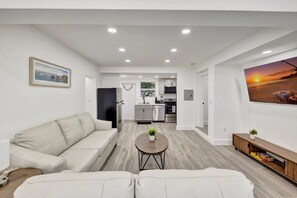 Un salon moderne avec un canapé, une table basse et un téléviseur.