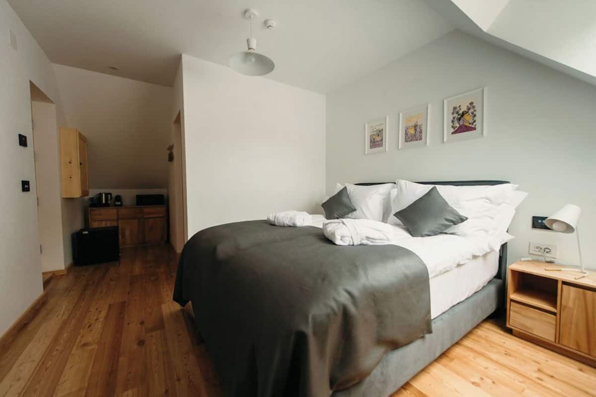 Un dormitorio con cama, mesita de noche y un pequeño armario de madera.