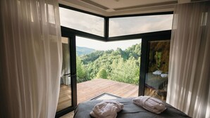 A bedroom with a large window offering a view of a forested area. - PurpleVague (Runcu)