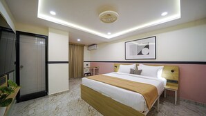 Una camera d'albergo moderna con un letto grande, una scrivania e una sedia.