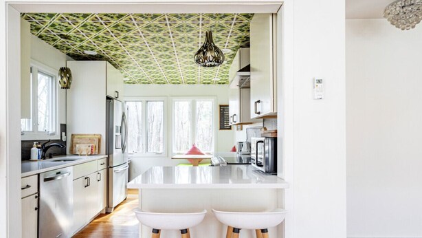 Una cocina moderna con una isla blanca, electrodomésticos de acero inoxidable y piso de madera.