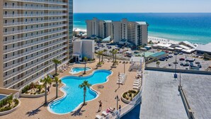 A hotel with a large pool, beach view, and multiple high-rise buildings.