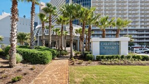 A hotel entrance with palm trees, a brick pathway, and a sign reading "LAKETOWN WHARF".
