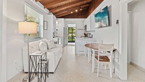 A modern kitchen with white cabinets, a dining table, and chairs. - Charming Naples Retreat – Your Perfect Getaway! (Naples)