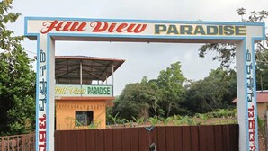 Señal que dice 'Fire View Paradise', con una estructura cubierta y una moto estacionada adelante.
