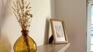 A wooden shelf with a vase of dried plants and a framed picture. - Charming Bright Duplex (Angers)