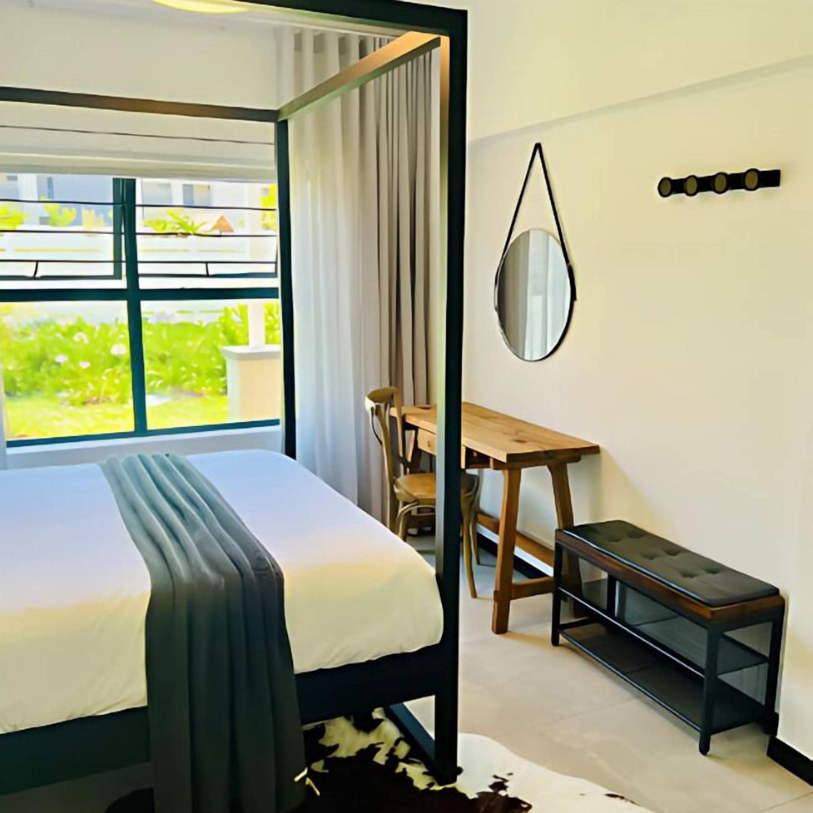 Une chambre à coucher comprenant un lit, un bureau, une chaise et une petite table.