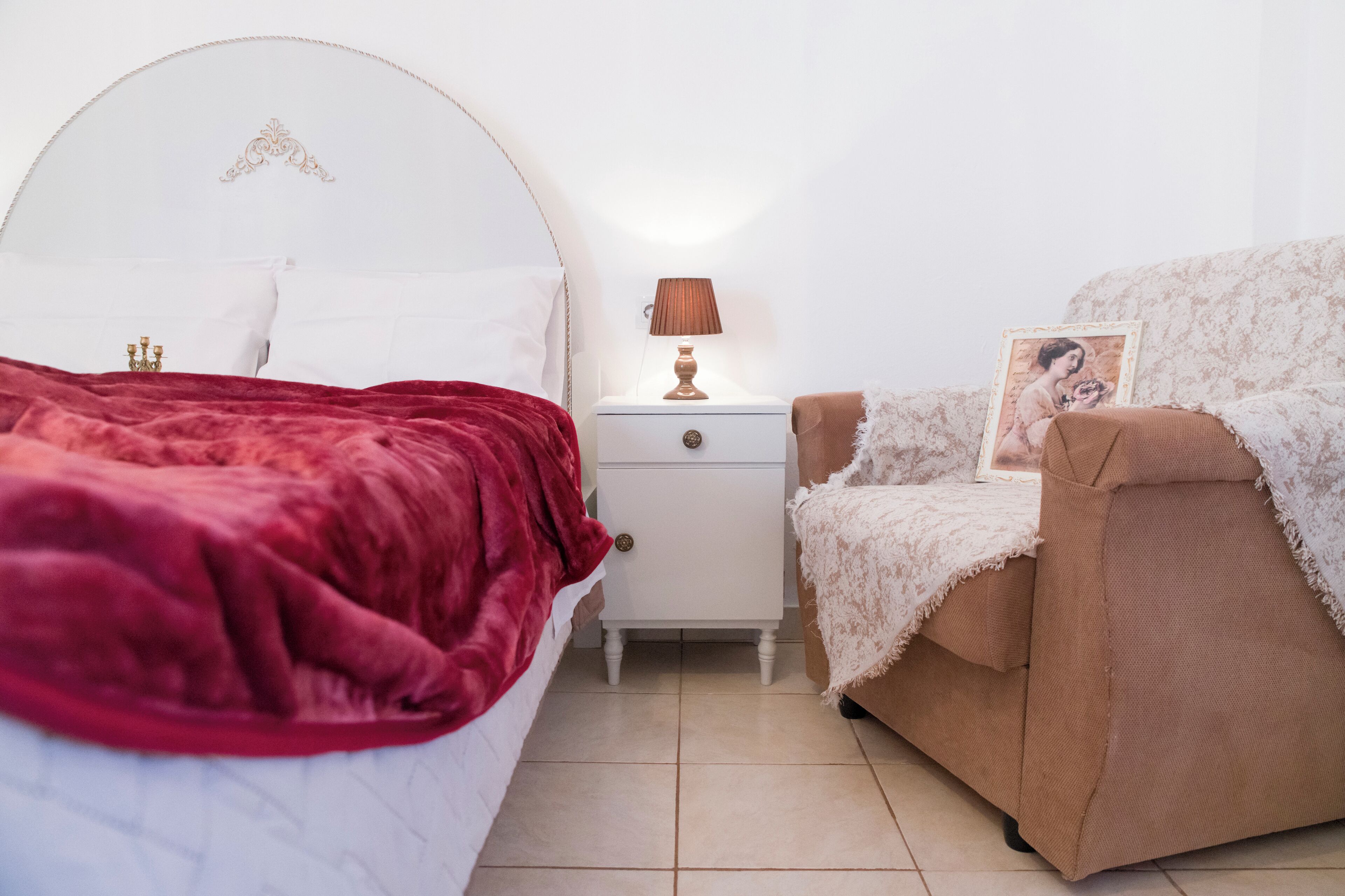 A bedroom with a bed, nightstand, and a chair.