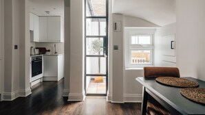 Una cucina moderna con mobili bianchi, forno integrato e un'ampia finestra.