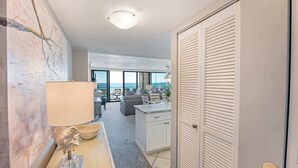 Une chambre d’hôtel moderne avec vue sur la mer, un coin repas et une cuisine.