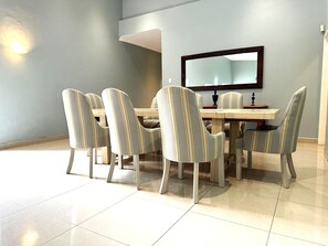 A dining area with a rectangular table and six chairs with striped upholstery.