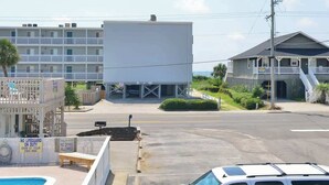 A motel with a swimming pool, a lifeguard station, and a parking lot.