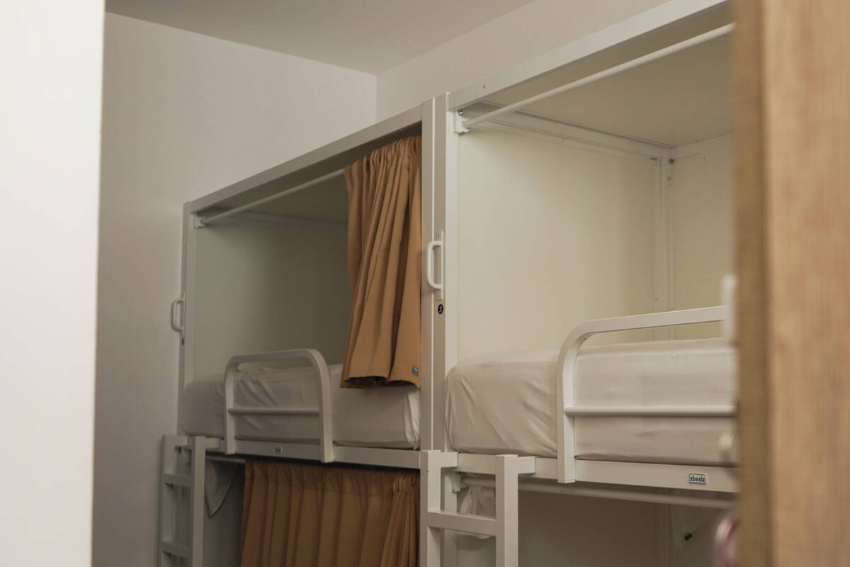 Habitación con literas, con una cortina en la litera inferior.