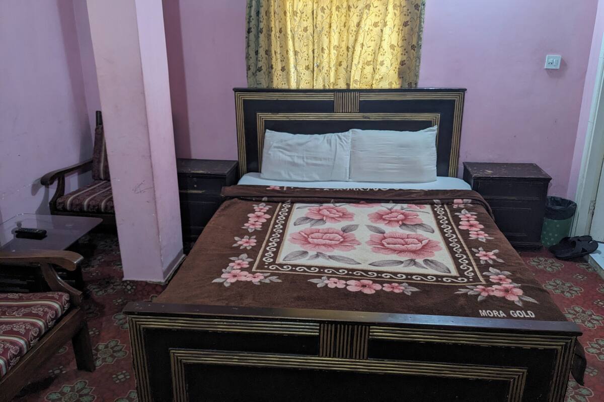 Une chambre à coucher avec un lit, une table de chevet, une chaise et une petite table.