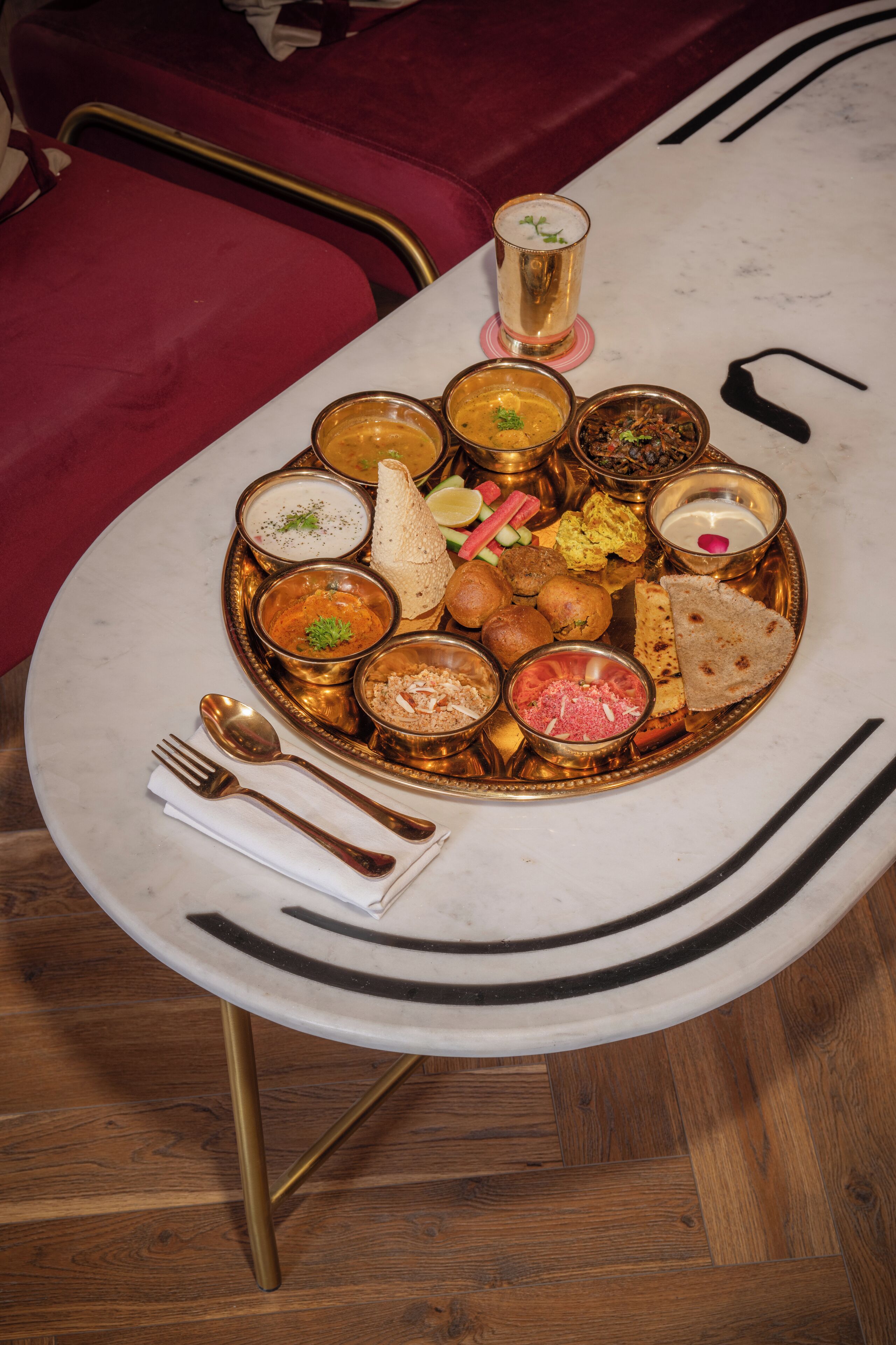 A dining table with a variety of dishes and a glass of beverage.