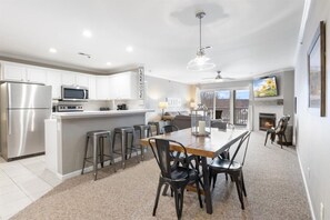 Enjoy meals in the kitchen and dining area with stainless steel appliances and a wooden table.