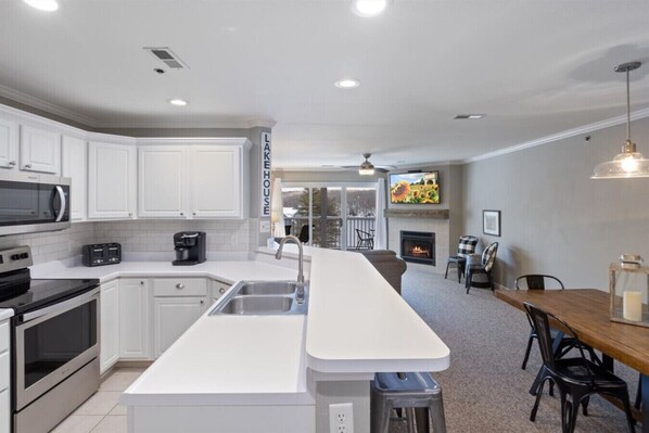 Enjoy cooking and dining in this well-equipped kitchen with a spacious island and dining area featuring a fireplace.