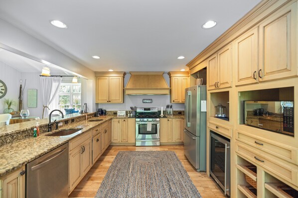 A modern kitchen with granite countertops, stainless steel appliances, and wooden cabinets.