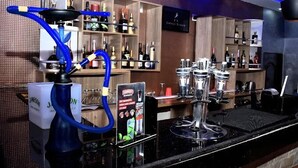 A bar area with a hookah, shelves of liquor bottles, and a sign reading "Frankie Miller". - Godfather's Place (Abuja)