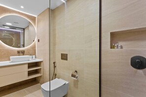 A modern bathroom with a large sink, toilet, and shower area.
