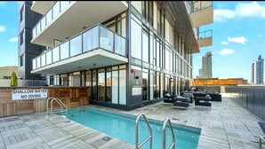 Une piscine sur le toit, avec un panneau indiquant une faible profondeur et interdisant la plongée.
