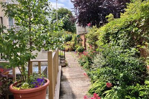 A narrow garden path with potted plants and a wooden fence on one side. - Beach House Apartment, Sleeps 4 With Patio (Southport)