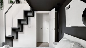A modern bedroom with a staircase, a bed, and a wardrobe. - Farini 74 Design Apartment – Metro M3, WiFi, AC (Milan)