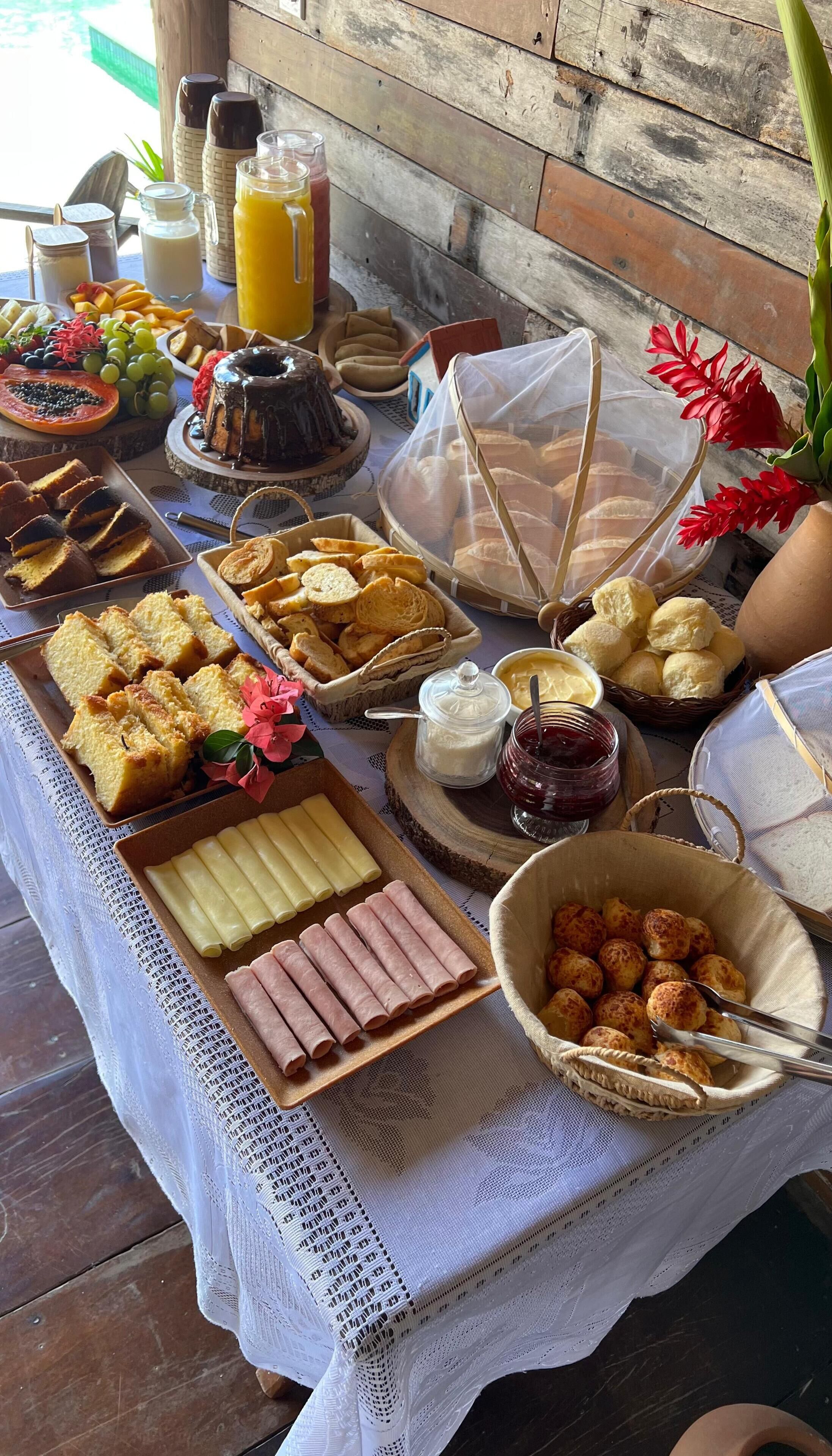 Een buffet met diverse gerechten, waaronder brood, gebak en een taart.