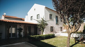 A white building with a tiled roof, a small garden, and a tree. - Country House (Serra do Bouro)