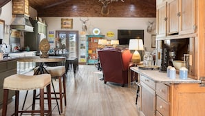 Una cocina rústica con armarios de madera, una isla central y una araña.
